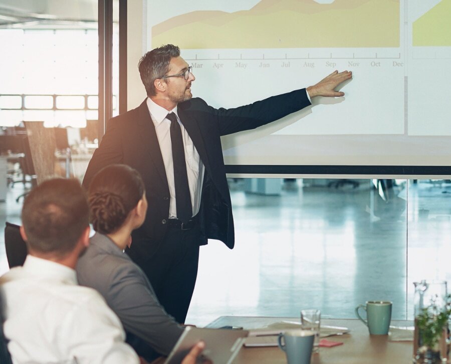 Businessman presents yearly trends to colleagues in a boardroom