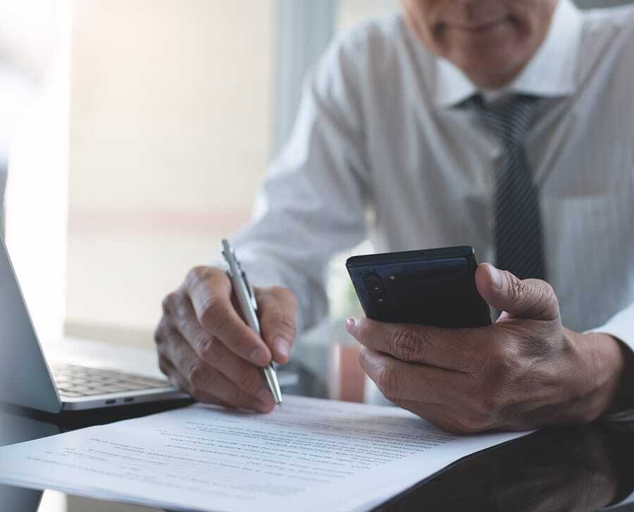 utility director signing a document while using a smart phone